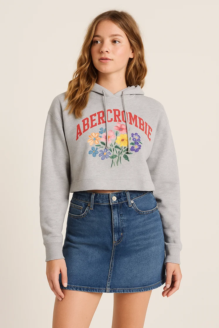 Модель в толстовке Abercrombie & Fitch и джинсовой юбке из денима.