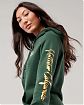 Женская толстовка с капюшоном Hollister зеленого цвета с фирменным золотым принтом на рукаве и груди. Модель 06033. Подробное описание и цена товара. Доставка по России, Москве и Области от Moscow USA
