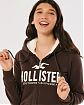 Женская меховая толстовка на молнии и с капюшоном Hollister коричневого цвета с белой нашитой надписью. Модель 06531. Подробное описание и цена товара. Доставка по России, Москве и Области от Moscow USA