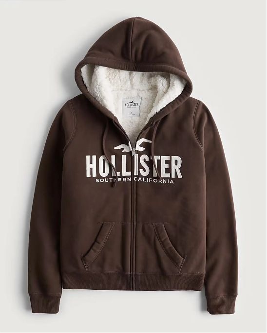 Женская меховая толстовка на молнии и с капюшоном Hollister коричневого цвета с белой нашитой надписью. Модель 06531. Подробное описание и цена товара. Доставка по России, Москве и Области от Moscow USA